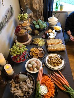 a table filled with lots of food next to a window