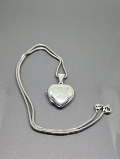 925 Sterling Silver - Heart Etched Design Locket pendant with Chain ST016 Jewellery Type: Locket Pendant with Chain Metal: Sterling Silver 925 Size: 50cm Snake Chain, Locket 3cm long with 2cmx2cm Heart Motive: Heart Locket Necklace Stones: N/A Condition: Not new Item Weight: 8gr Items included: Pendant with Chain only Other Comments: None Please note that this is a used item. Items are it very good condition but may need cleaning, Other Comments may contain notes on item if any missing stones/da Silver Heart Pendant Necklace Stamped 925, Silver Heart Pendant Necklace With Silver Chain, Classic Silver Heart Pendant Necklace, Silver Heart Necklace Stamped 925, Silver Heart Pendant Necklace For Anniversary, Silver Heart Locket Necklace Classic Style, Silver Round Locket Heart Necklace, Silver Heart Locket Necklace For Anniversary, Silver Sterling Silver Heart Pendant Locket Necklace