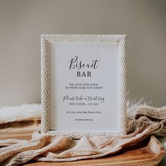 a white framed sign sitting on top of a wooden table