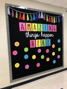 a bulletin board with the words amazing things happen here written in bright colors on it