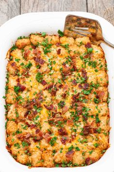 a casserole dish with bacon, cheese and parsley in it on a wooden table