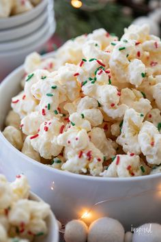 a bowl filled with white and green sprinkles on top of a table