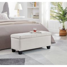 a bedroom with a large bed and a small footstool in front of it