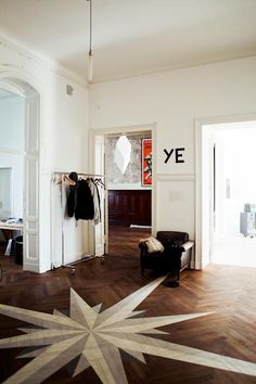 a room with wooden floors, white walls and a large star pattern on the floor