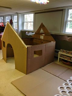 the cardboard house is made to look like it has been built into the floor and walls