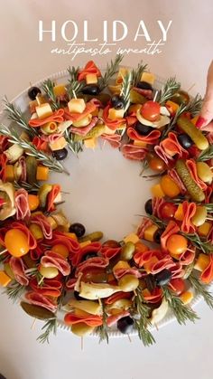 a wreath made out of fruits and vegetables on a white surface with the words holiday written above it