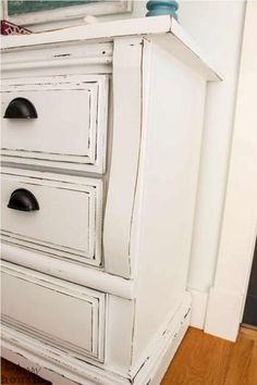 an old white dresser with three drawers