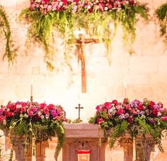 the altar is adorned with flowers and greenery