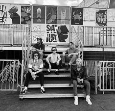 black and white photograph of four people sitting on stairs