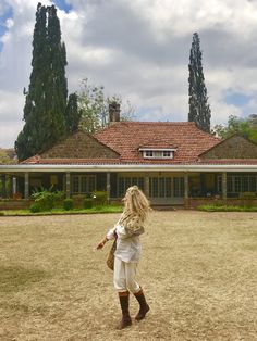 a woman standing in front of a large house