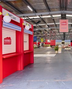 the inside of a store with red and white booths on both sides of the building