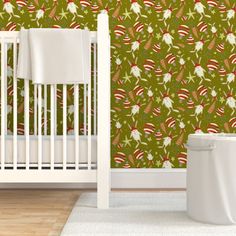 a white crib in front of a wall with red berries and green leaves on it