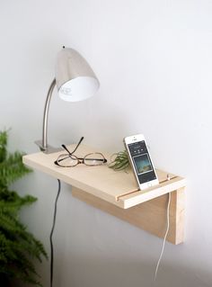 a phone is sitting on top of a table with a lamp and eyeglasses