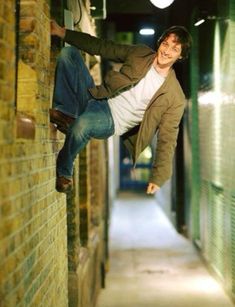 a man hanging off the side of a brick building