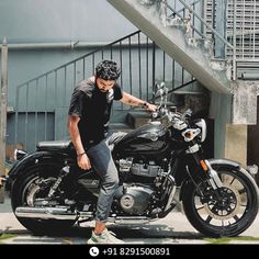 a man sitting on top of a motorcycle in front of a stair case and building