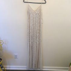 a dress hanging on a hanger next to a wall