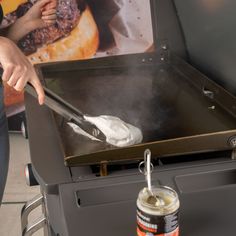 a person cooking food on top of a grill with a spatula in front of it