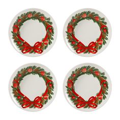 four white plates with red bows and christmas wreaths on them