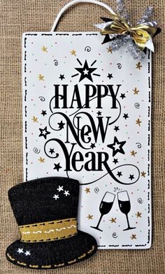 a new year's card with a top hat and two glasses on it, next to a bottle of wine