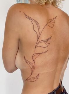 the back of a woman's body with a flower tattoo on her left side