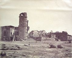 an old black and white photo of people walking in front of some buildings that have been destroyed