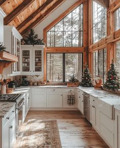 a kitchen with wooden ceilings and white cabinets, christmas trees in the window sill