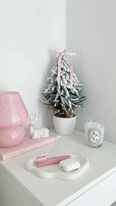 a white desk with a pink christmas tree and other items on it, including an electric toothbrush