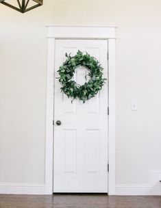 a white door with a wreath on it