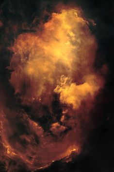 an orange and yellow cloud in the sky with dark clouds behind it on a black background