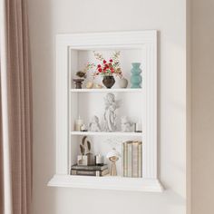 a white shelf filled with books and vases