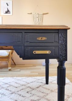 an old dresser is painted black with gold hardware and pulls on the drawer, along with a white rug