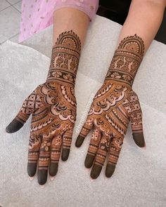 two hands with henna designs on them