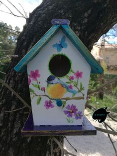 a bird house painted with flowers and butterflies