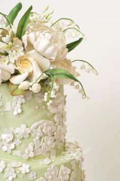 a green wedding cake with white flowers on top