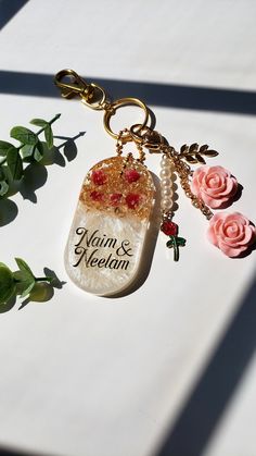 a keychain with some flowers on it and a name tag attached to it