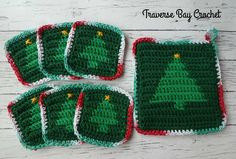 four crocheted christmas tree coasters on a table