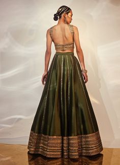 Presenting the Green and Gold Embellished Silk Lehenga Set, crafted from luxurious dola silk, is a true masterpiece that blends traditional elegance with a contemporary twist. The deep green lehenga is adorned with intricate hand embellishments, infusing the ensemble with a regal charm that’s hard to miss. Teamed with the blouse is thoughtfully designed to harmonize with the rich tones of the skirt, while the matching dupatta drapes effortlessly, adding to the outfit's overall opulence. Ideal for Mehndi, Sangeet, or as a stunning choice for wedding guest attire, this lehenga set promises to make you the center of attention at any event. Composition : Blouse, Lehenga and Dupatta - Dola Silk Care: Dry Clean Only and Vacuum Storage This product can be customized for sleeves, blouse length and Green Lehenga Choli Wedding, Green Blouse Lehenga, Saree For Wedding Guest Indian Outfits, Silk Lehnga Outfit, Green Choli Lehenga, Wedding Guest Indian Outfit, Mehndi Green Lehenga, Green Saree Blouse Designs, Saree Lehenga Design