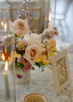 Colorful Cape Cod wedding centerpieces. The image shows the colorful centerpieces on a table which has a light blue patterned table linen with colorful taper candles and cane table numbers. The table is in the reception space at the Coonamesset on Cape Cod, a Falmouth wedding venue. Wedding Centerpiece, Wedding Colors, Summer Wedding