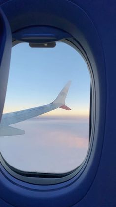 an airplane window looking out at the clouds