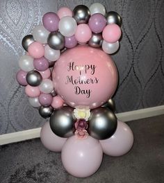 a balloon arch with balloons attached to it and the words happy mother's day written on it