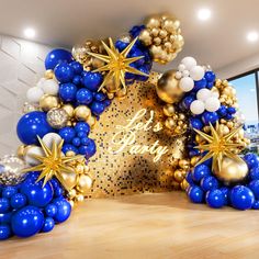 blue and gold balloon arch with happy new year written on the wall in front of it