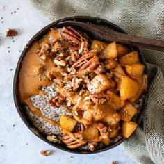 a bowl filled with oatmeal and pecans on top of a table