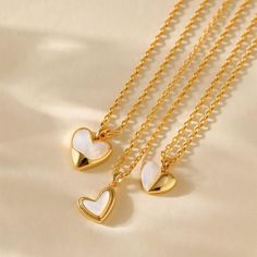 Elegant Design: An 18k gold-plated heart pendant featuring a natural mother-of-pearl accent for a touch of timeless beauty. Three Variations: Available in three captivating color combinations to suit your personal style. Everyday Wear: Crafted with durable materials for long-lasting wear and easy care. Adjustable Length: The chain measures approximately 19.5 inches, allowing for a customized fit. Versatile Accessory: Suitable for various occasions, from casual outings to special events. White Clavicle Chain Heart Necklace For Anniversary, White Heart Clavicle Chain Necklace For Anniversary, Anniversary White Heart Clavicle Necklace, White Heart Necklace With Clavicle Chain As Gift, White Heart Clavicle Chain Necklace As Gift, White Heart Pendant Necklace With Clavicle Chain, White Heart Pendant Necklace As Gift For Her, Gold Heart Necklace With Pearl Pendant For Valentine's Day, White Heart-shaped Necklace As A Gift For Her