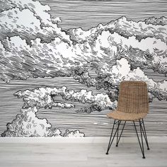 a chair sitting in front of a black and white wall mural with clouds on it