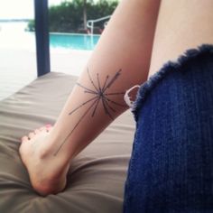 a woman's foot with a tattoo on the side of her leg next to a pool