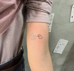 a woman's arm with a small tattoo of an elephant and a cupcake on it