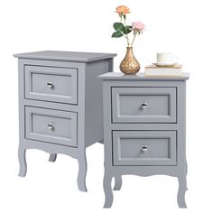 two gray nightstands with flowers and a coffee cup on the top one is empty