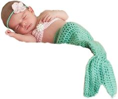 a newborn baby wearing a green crochet mermaid tail