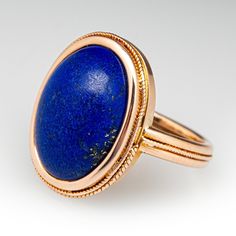 This distinctive ring features a bezel set oval cabochon lapis lazuli and delicate twisted rope design around the bezel and band. It is crafted in 14k yellow gold with a light patina. This ring is currently a size 7.25. Part of the twisted bezel detail is missing but this does not take away from the charm of the ring. Luxury Oval Lapis Lazuli Rings, Elegant Lapis Lazuli Ring With Polished Finish, Formal Oval Jewelry With Fluted Bezel, Luxury Oval Lapis Lazuli Jewelry, Elegant Lapis Lazuli Rings For Formal Occasions, Luxury Lapis Lazuli Oval Rings, Elegant Formal Lapis Lazuli Rings, Oval Lapis Lazuli Rings For Formal Occasions, Formal Lapis Lazuli Oval Rings