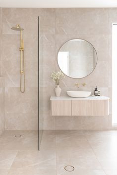 a bathroom with a sink, mirror and shower head in it's center wall